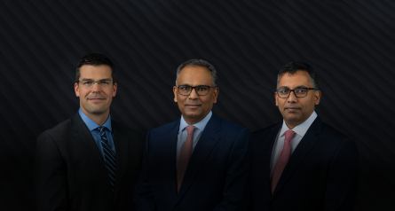 headshots of three men in suits on dark background